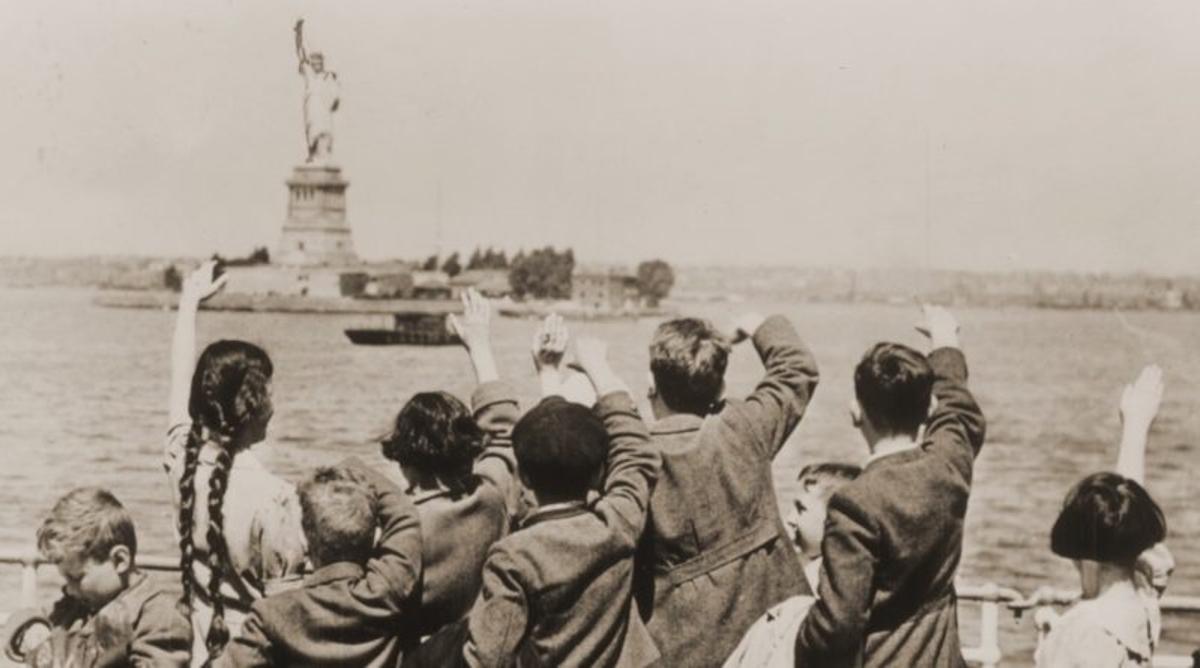 Los niños migrantes saludan a la Estatua de la Libertad a su llegada a Nueva York.