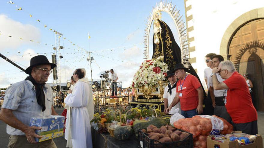 Los voluntarios de Cáritas reciben las ofrendas junto a la Virgen, ayer.