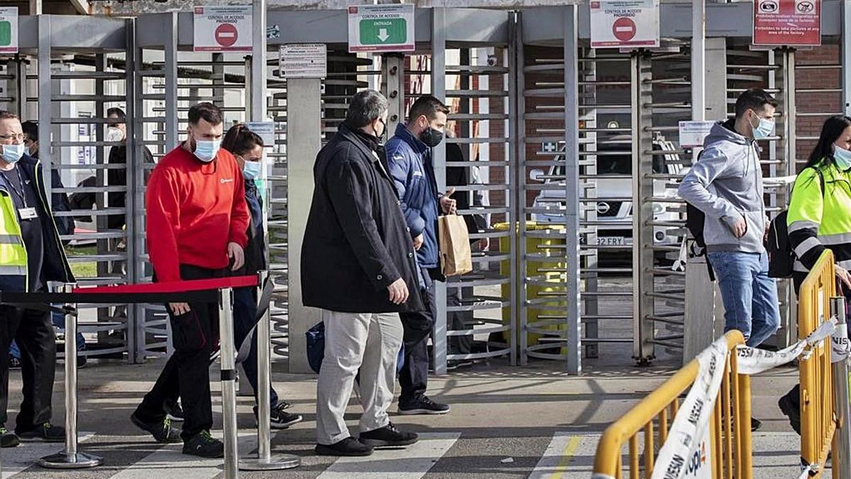 Unos trabajadores, al finalizar su turno, en un polígono de la Zona Franca de Barcelona.  | FERRAN NADEU