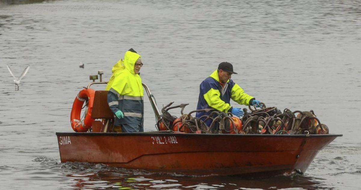 Los vigilantes de la Xunta precintando las nasas, ayer. | |