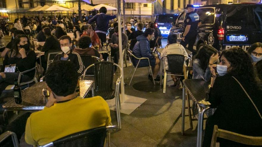 Clientes en una terraza ovetense de noche.