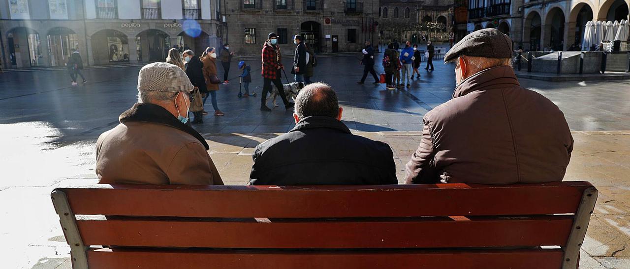 Un grupo de personas mayores en la plaza de España de Avilés.
