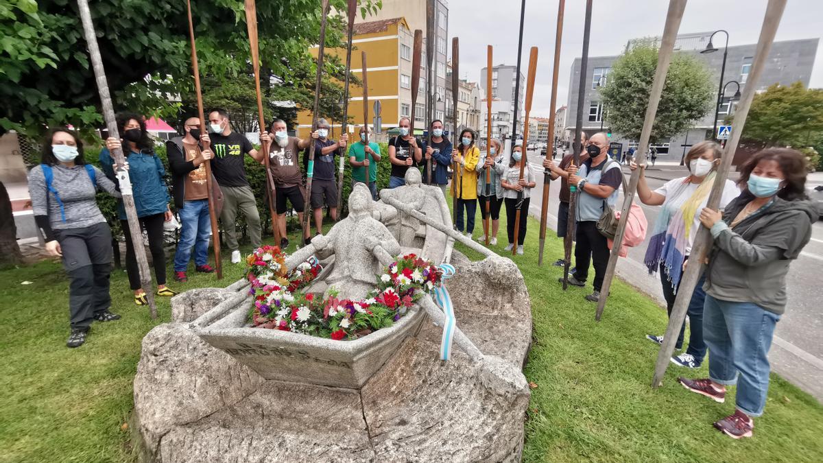 Momento del homenaje en la escultura con los remos en alto.