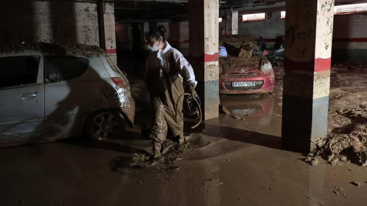 Vecinos limpiando un garaje en Paiporta el pasado jueves.
