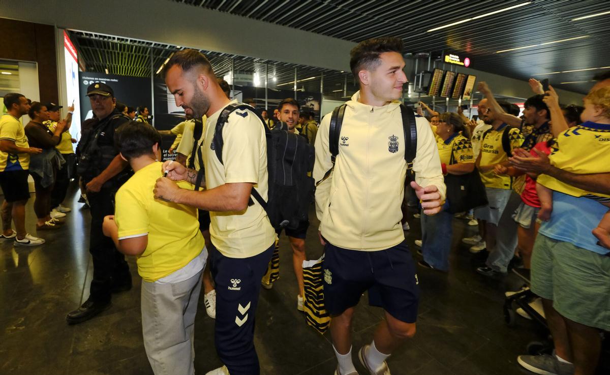 Aficionados reciben a la UD Las Palmas en el aeropuerto tras sellar el playoff