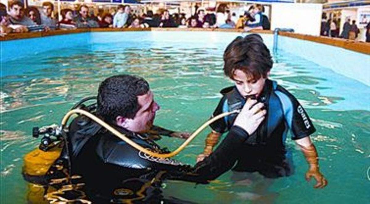 Un nen aprèn a utilitzar el material de submarinisme. Un nen aprèn a utilitzar el material de submarinisme.