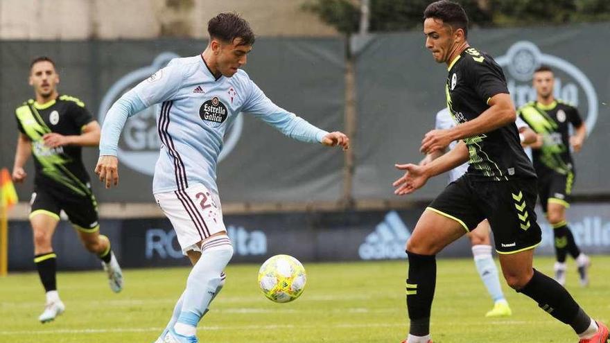 Iker Losada, del Celta B, intenta controlar el balón ante la presión de un jugador del Rayo Majadahonda. // Alba Villar