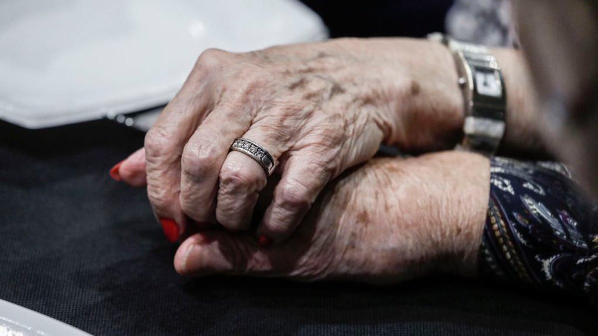 Dos personas mayores se cogen de la mano