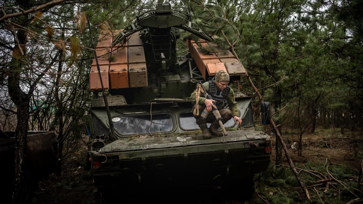 Un miembro de la batería desciende de un 9K33 Osa en un bosque del Donbás.