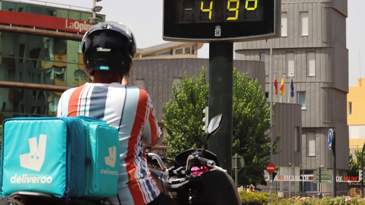 Un trabajador frente a un termómetro en Murcia.