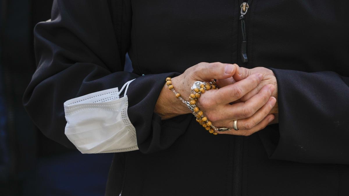 Eine Gläubige hält einen Rosenkranz in der Hand, während sie auf dem Petersplatz im Vatikan mit anderen Gläubigen das Angelusgebet des Papst mitverfolgt. Während des traditionellen Sonntagssegens betete der Papst für eine friedliche politische Lösung des Ukraine-Konflikts.