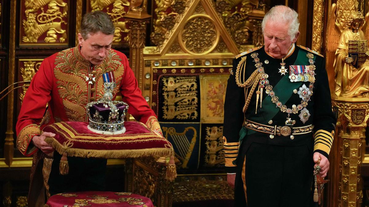 El Príncipe Carlos, Príncipe de Gales observa cómo la Corona del Estado Imperial se coloca a su lado en la Cámara de los Lores durante la Apertura Estatal del Parlamento en las Casas del Parlamento, en Londres, el 10 de mayo. 2022