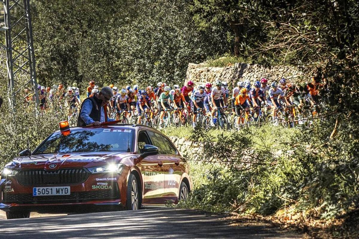El coche de Rubèn Peris, responsable de la carrera, precede al pelotón de la Volta 2025.