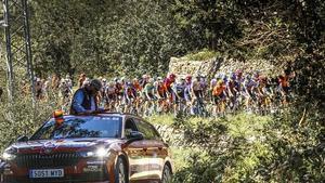 El coche de Rubèn Peris, responsable de la carrera, precede al pelotón de la Volta 2025.