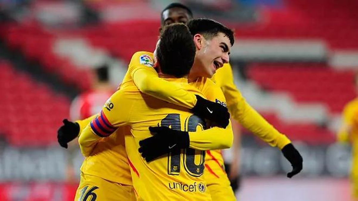 Pedri y Messi se abrazan mientras celebran un gol.