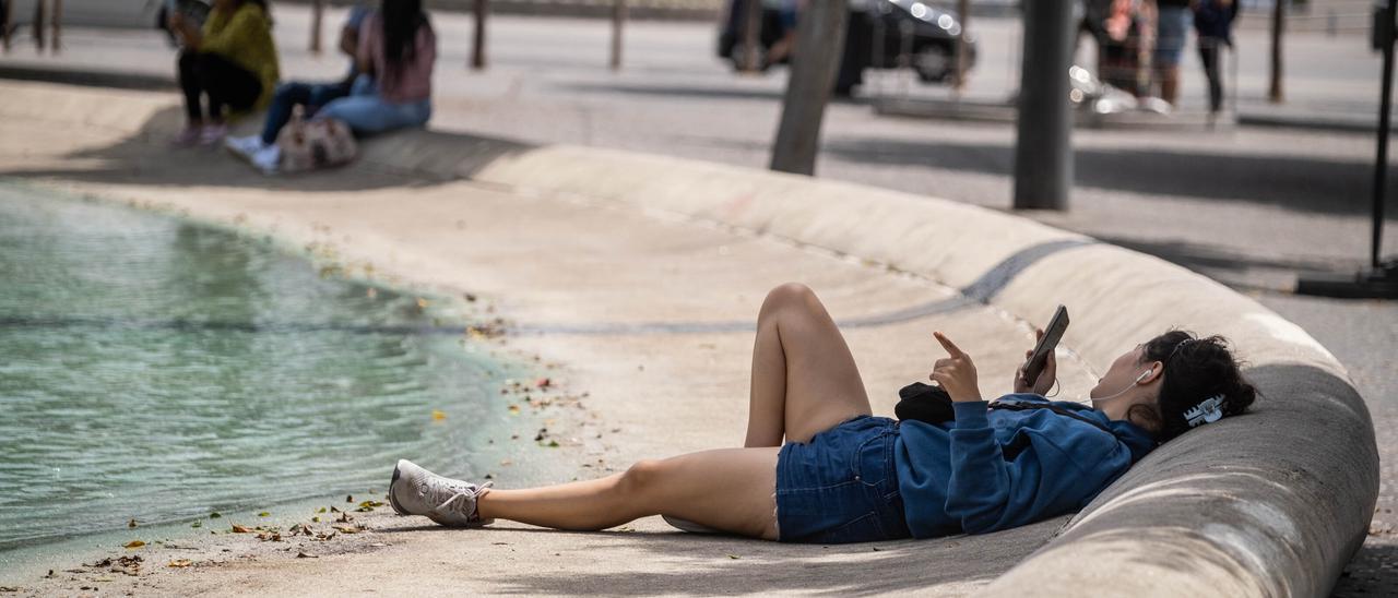 Una mujer aprovecha una zona de sombra en la Plaza de Candelaria para huir del calor.