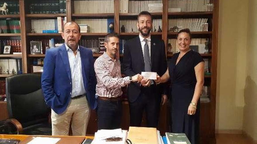 De izda. a dcha.: Rodríguez, Salvador García, V. Padín y Eva García durante la entrega del cheque, ayer en la Notaría de Tui. // D.B.M.