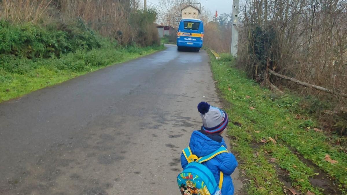 Uno de los niños sin transporte, viendo pasar el autobús con sus compañeros.