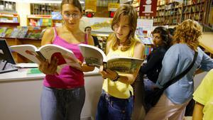 Dos adolescentes ojean sus nuevos libros de texto en la Librería Abacus. 