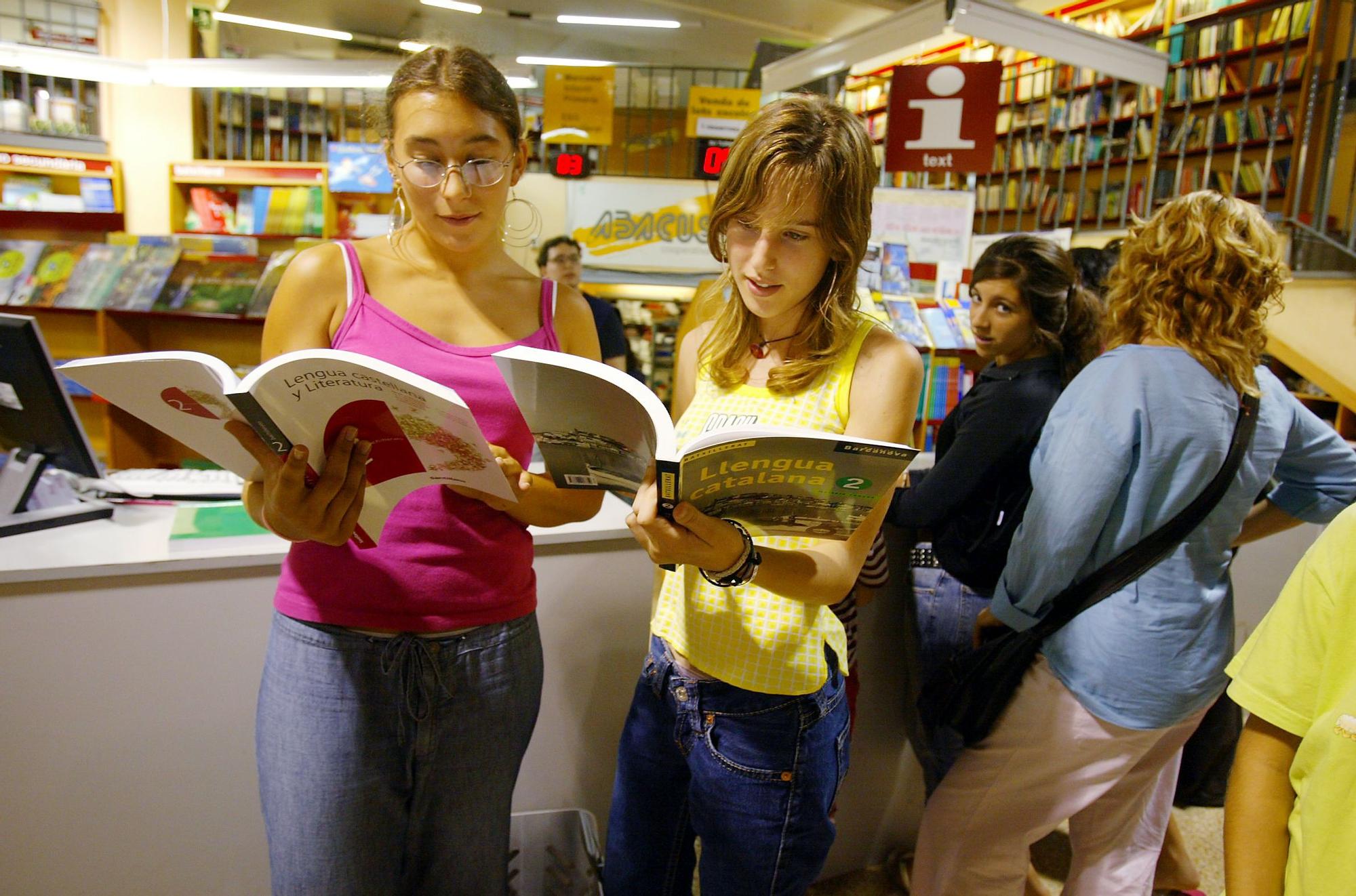 Dos adolescentes ojean sus libros de texto