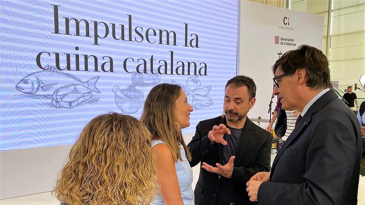 El president de la Generalitat, Salvador Illa (derecha), charla con la cocinera Laia Coma (Mare de la Font, de espaldas), la periodista Trinitat Gilbert y el chef Eduard Xatruch (Disfrutar), este lunes en el Teatre Nacional de Catalunya tras la presentación del plan de acción para el impulso a la cocina catalana.