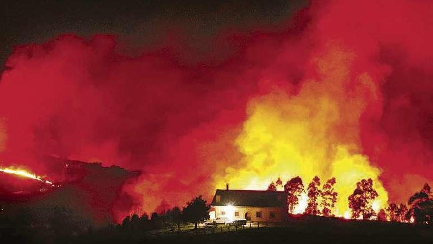 Una casa, anoche, rodeada por las llamas en El Franco. // LNE