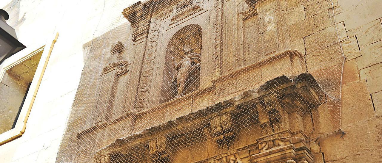 Una de las redes que protegen la basílica de Santa María ante el gran estado de deterioro que presenta la casa del Misteri. |