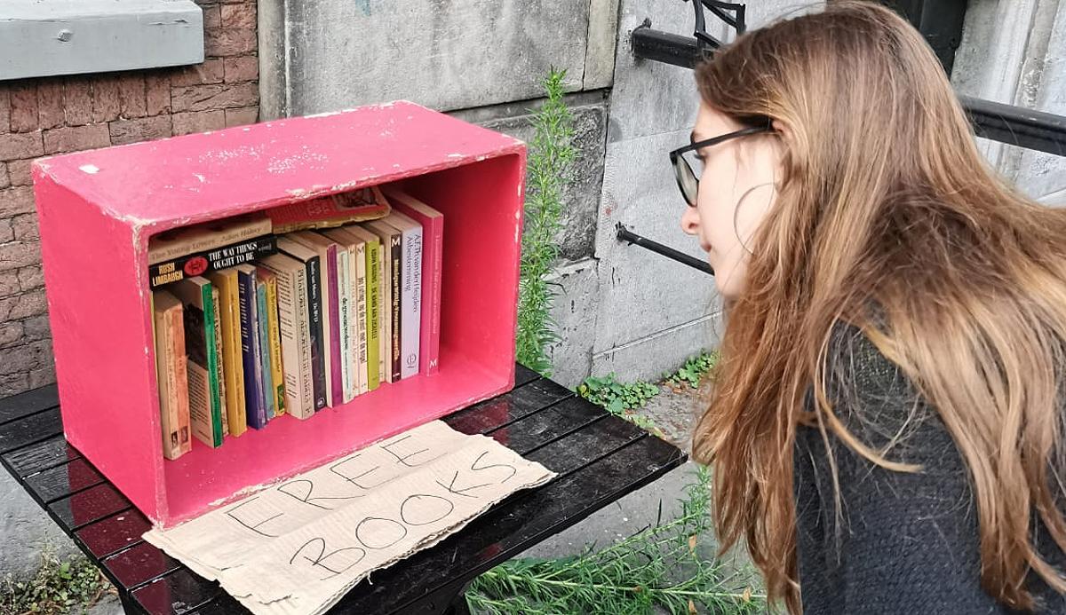 Una joven observa una caja con libros ‘libres’ en Ámsterdam.