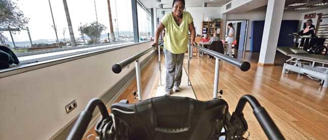 Una lesionada medular en la barra de ejercicios del amplio y diáfano gimnasio de neurorehabilitación del hospital Sant Joan de Déu.