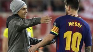Un fan que saltó al campo se dispone a abrazar a Messi durante el partido de este martes.