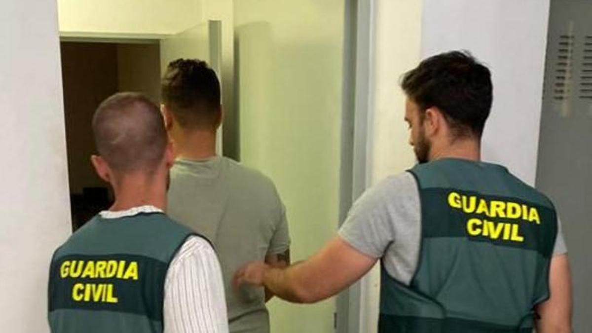 El detenido, custodiado por dos guardias civiles.