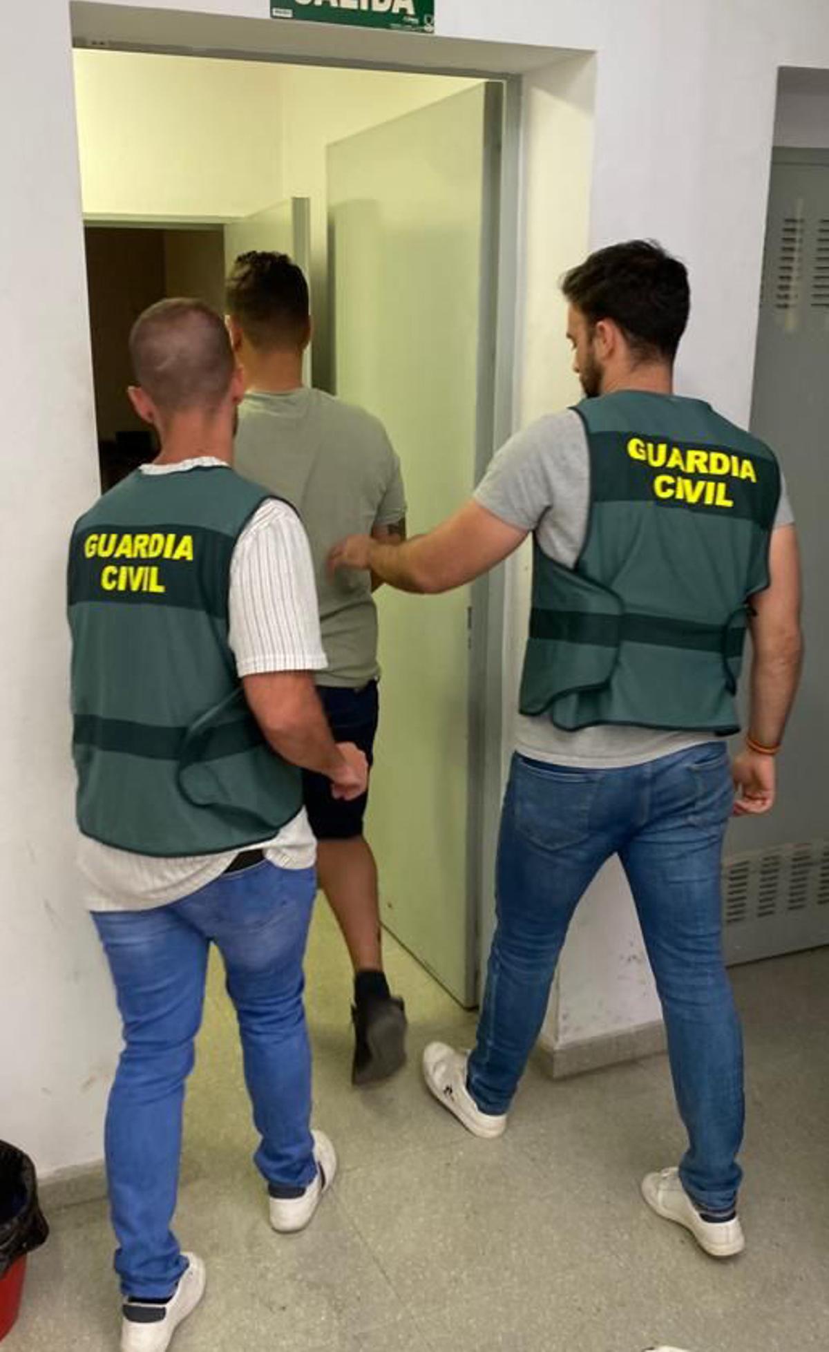 El detenido, custodiado por dos guardias civiles.