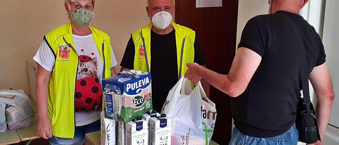 Pilar Ferrando y Vicent Castelló, ayer, junto a decenas de bolsas con comida para repartir en la sede del banco de alimentos.