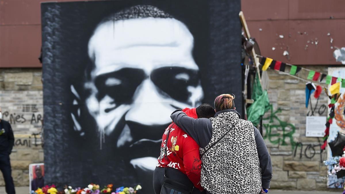 Una pareja se abraza frente al retrato de George Floyd, este martes, en Mineápolis, el 20 de abril de 2021