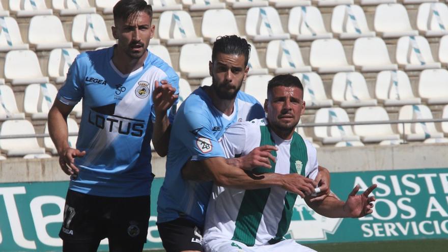 Xavi Molina trata de zafarse de dos jugadores de la Balompédica Linense en El Arcángel.