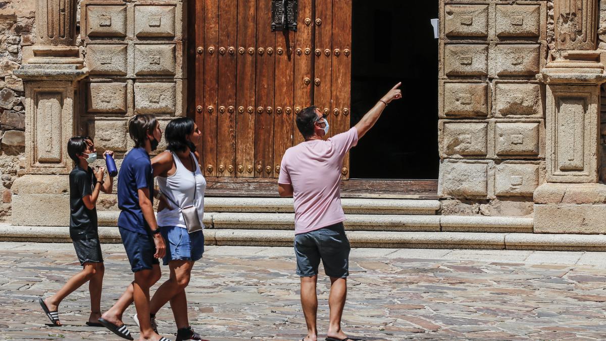 Cuatro turistas pasean ayer por la mañana por la plaza de Santa María de Cáceres frente al Palacio Episcopal.