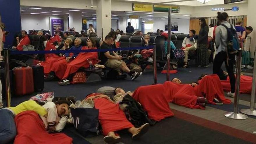 Los pasajeros atrapados tratan de dormir en el aeropuerto.