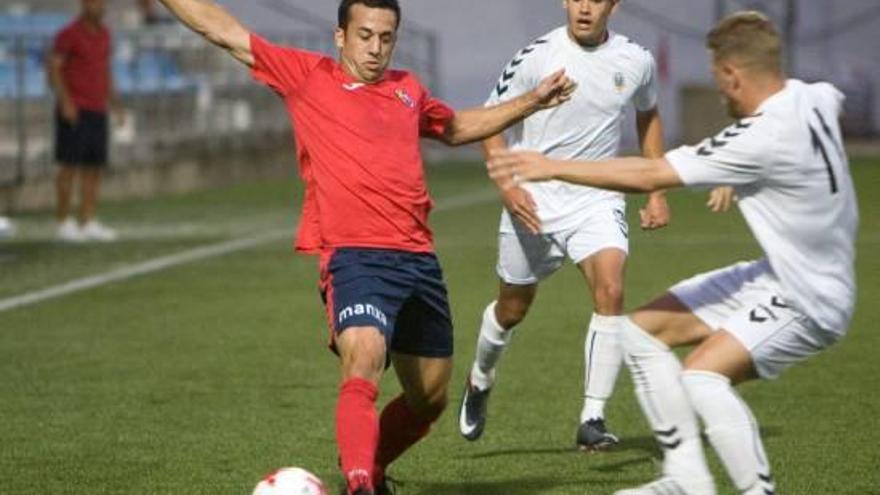 Micaló, envoltat de dos jugadors de l&#039;Olímpic de Xàtiva en el partit de la primera ronda.