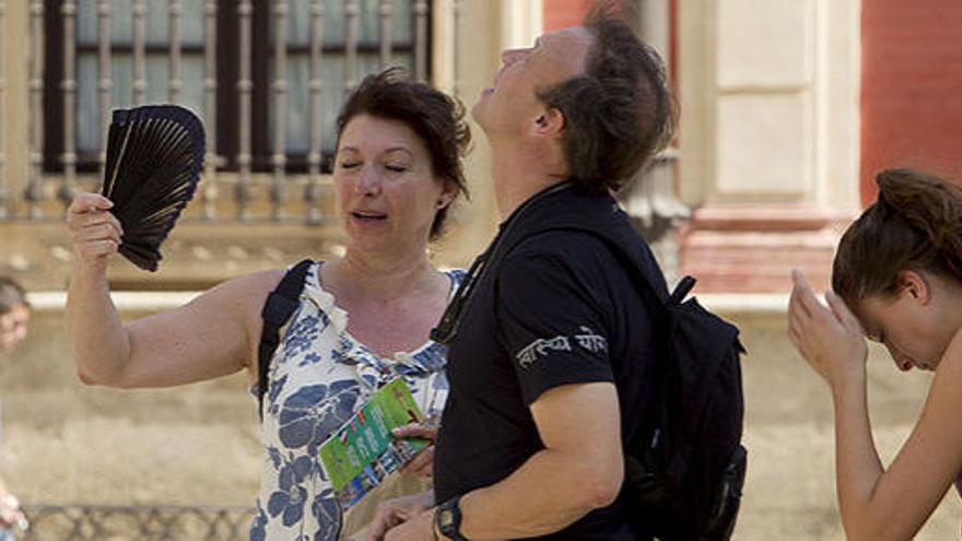 Turistas se abanican ayer en Sevilla