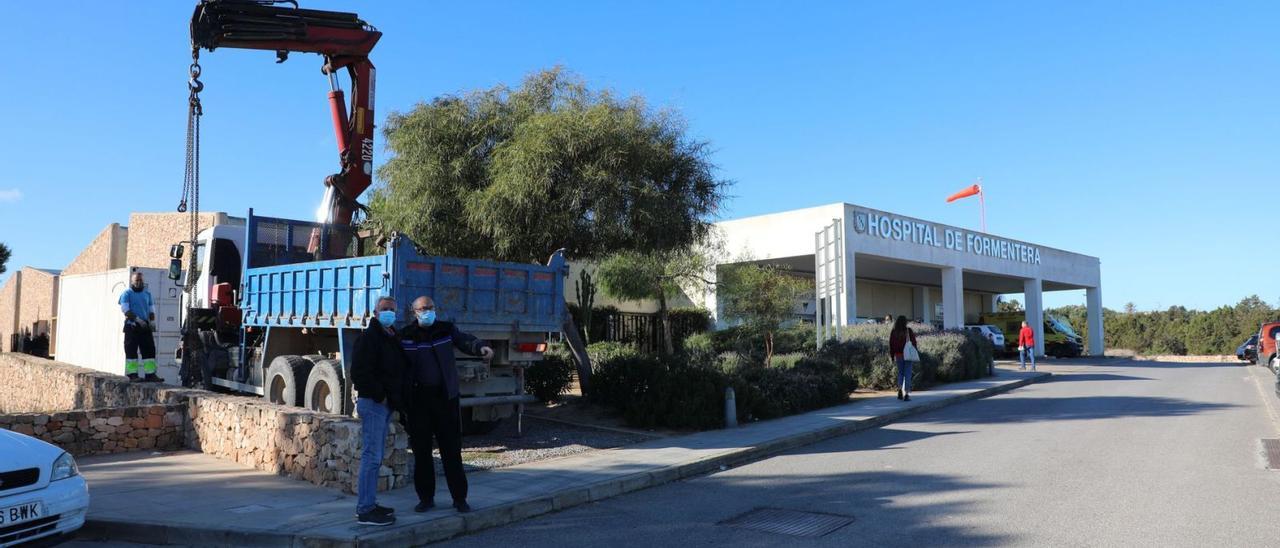 Un camión coloca junto al centro sanitario un contenedor con distintos materiales.