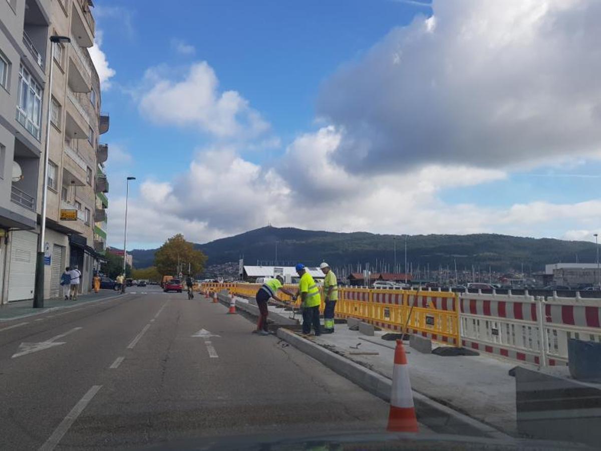 Operarios levantando un nuevo espacio de acera. | // G.N.
