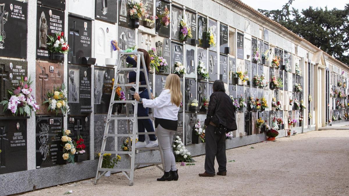Unos visitantes adecuan las tumbas de familiares en el cementerio de Xàtiva, en una imagen de archivo.