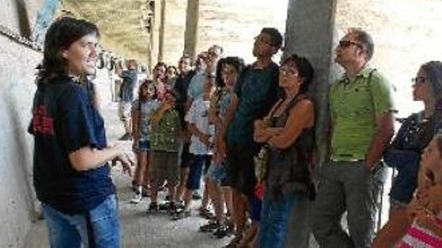 Visitants seguint l&#039;explicació de la guia durant el recorregut per l&#039;interior de la presa de la Baells, dimecres