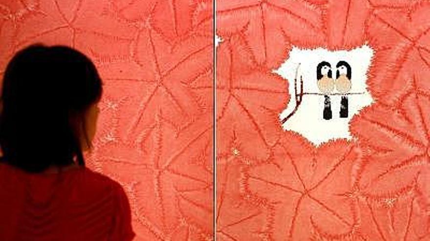 Una mujer observa la obra &quot;Pájaros en flores rojas&quot; de Chen Jialing, uno de los cinco artistas chinos que se han formado en el lenguaje tradicional de la escuela de Shangai y utilizan herramientas de sus antepasados, como la tinta, el pincel y el papel, para plantear nuevas técnicas y cuyas obras, de arte chino contemporáneo, acoge ahora el Instituto Valenciano de Arte Moderno (IVAM)..