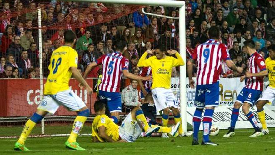 El meta del Sporting Alberto trata de despejar el remate de Aythami (d), ante Hernán Santana y Bernardo, en la acción del tanto del empate de la UD en El Molinón.