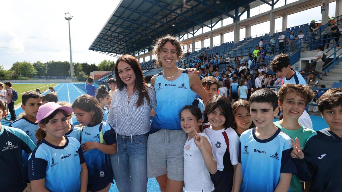 Daniela Fra y Emi Agüera, junto a los niños que se acercaron al acto de presentación de la renovada pista de atletismo de Arroyomolinos.