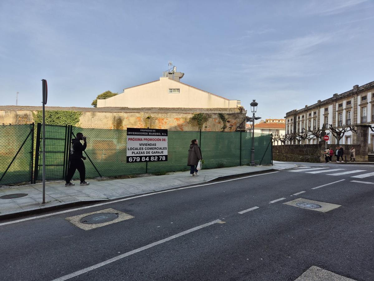 Solar junto al Liceo de Betanzos anunciando una nueva promoción de viviendas.