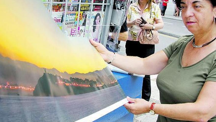 Paquita Alonso muestra la lámina de Gijón.