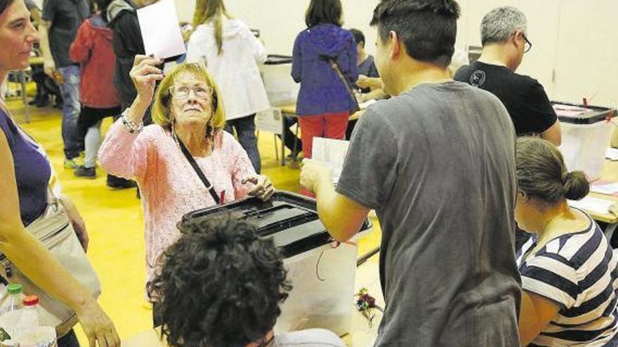 Una votante, a punto de depositar su papeleta en la urna, el 1-O de 2017.