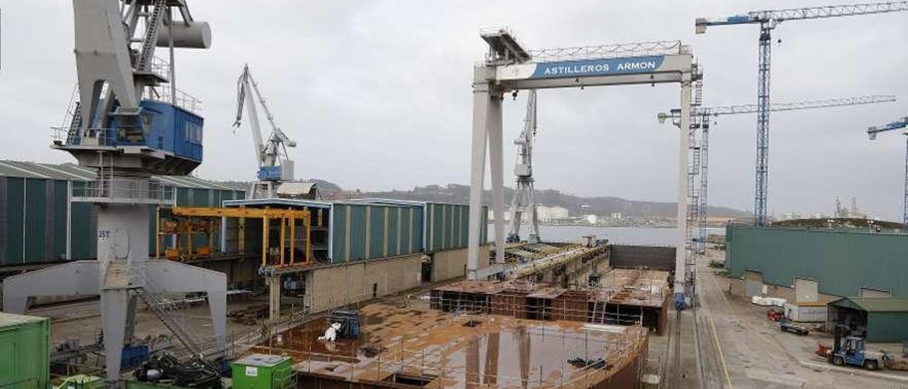 En primer término, bloques del barco para Blue Marine junto al dique seco principal de Armón Gijón, en el que entrará el casco de la nave, que se está construyendo en Turquía.